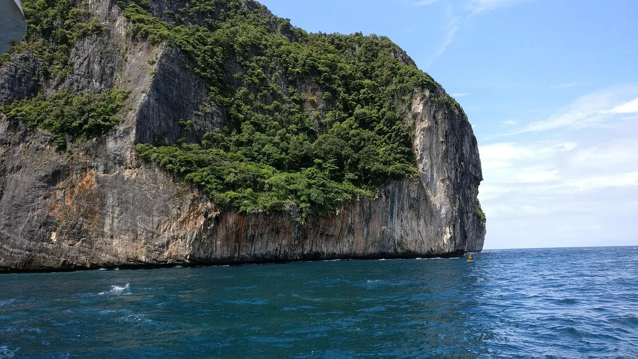 Limestone cliffs rising out of clear water.